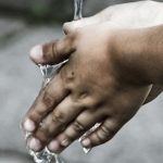 Ihminen pesee käsiä juoksevan veden alla.