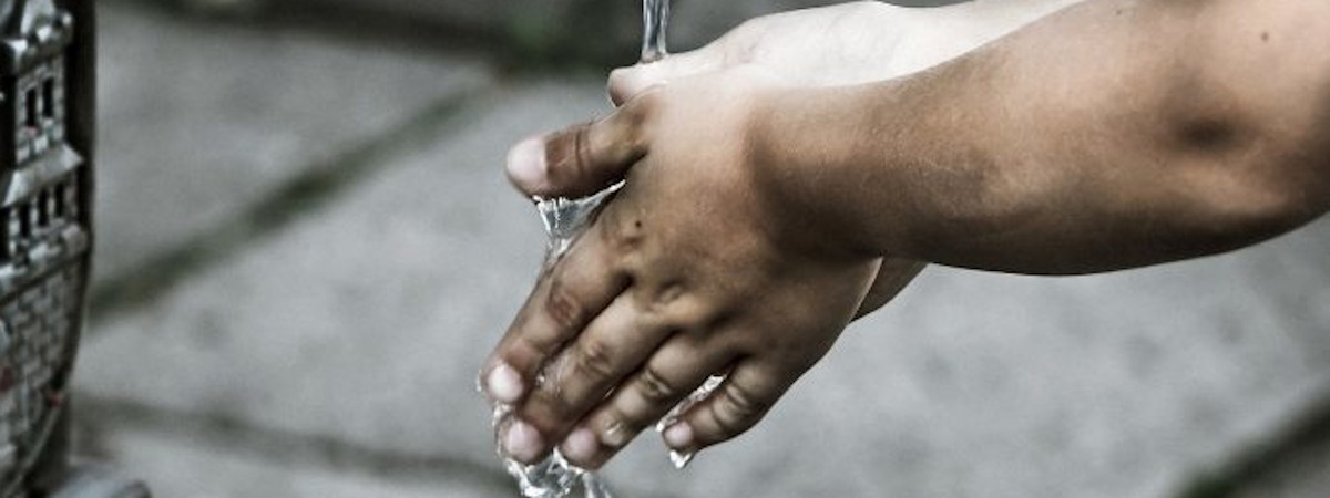 Ihminen pesee käsiä juoksevan veden alla.