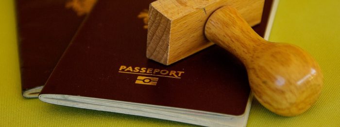 Kaksi passia ja puinen leimasin.